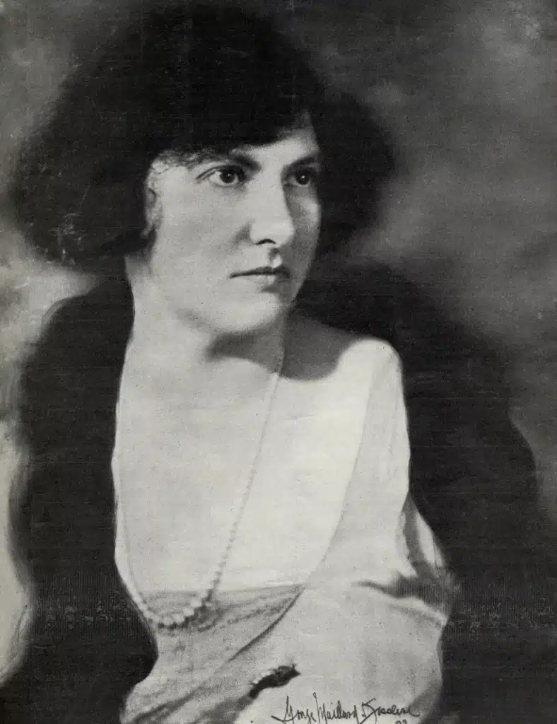 Black-and-white portrait of Marion Bauer with her hands resting in her lap and a handwritten signature at the bottom.