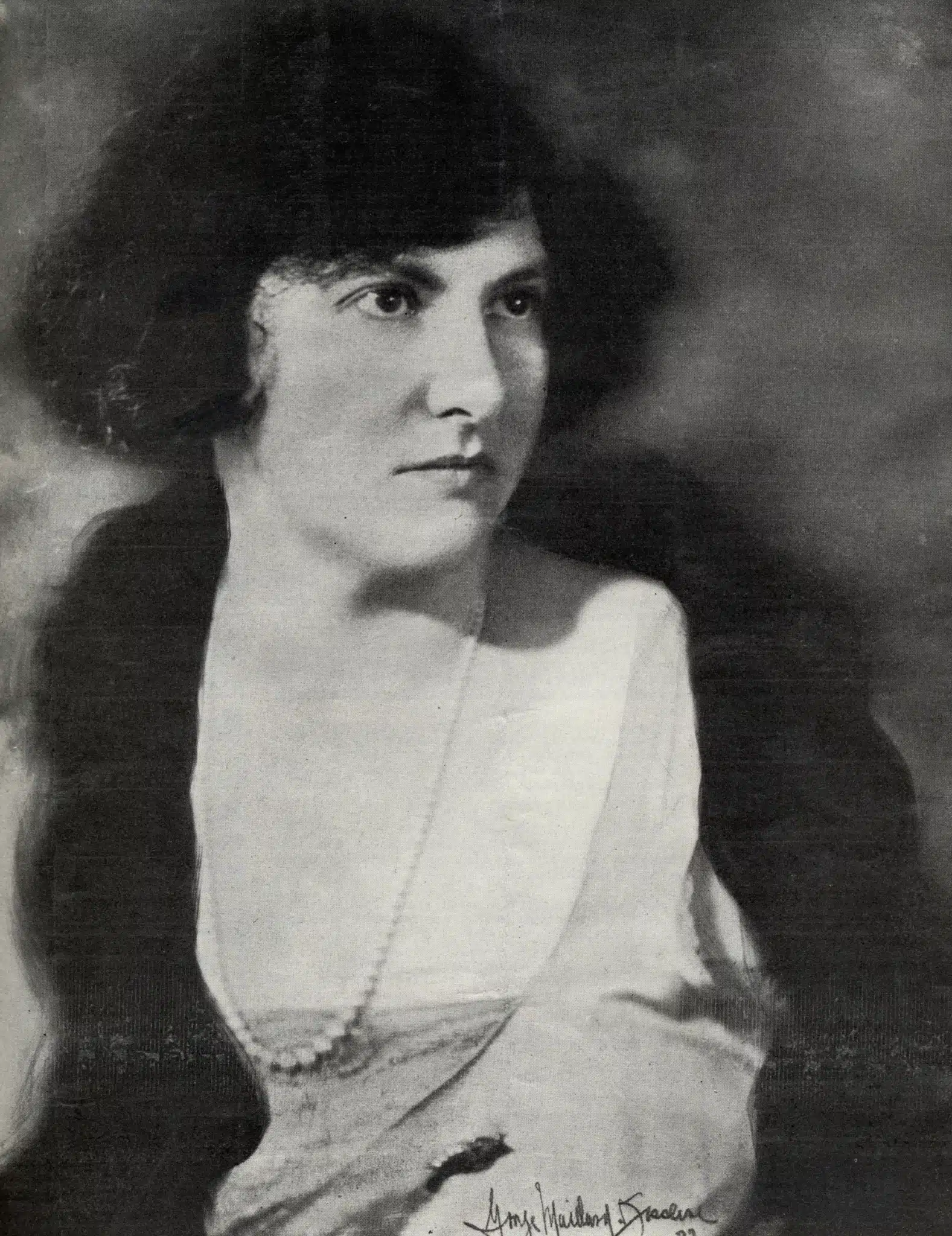 Black-and-white portrait of Marion Bauer with her hands resting in her lap and a handwritten signature at the bottom.