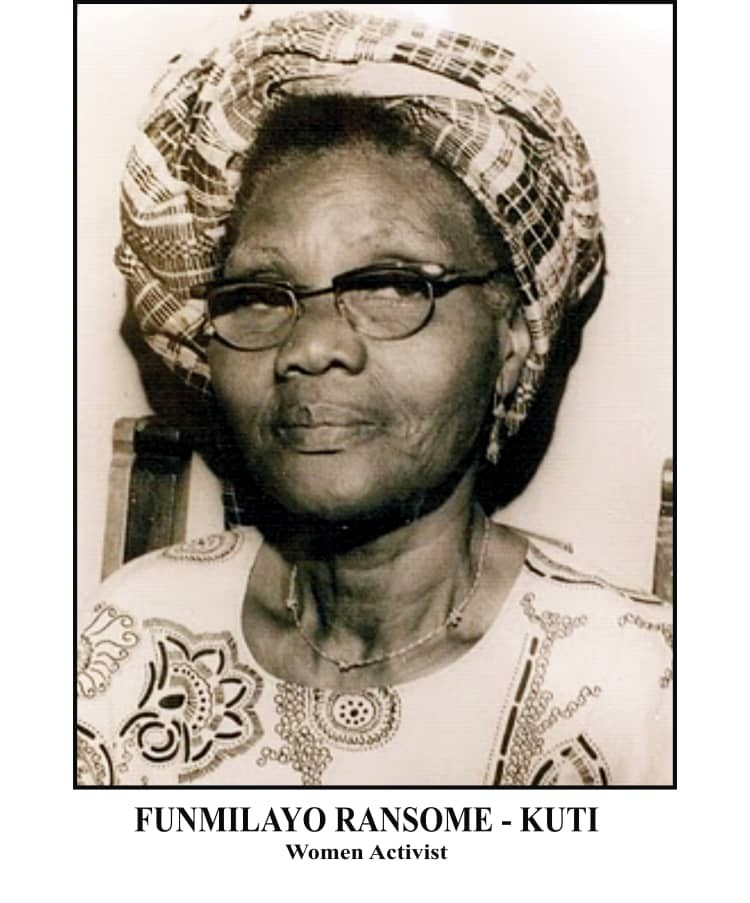 Funmilayo Ransome-Kuti wearing glasses and a patterned headwrap, looking to her right.