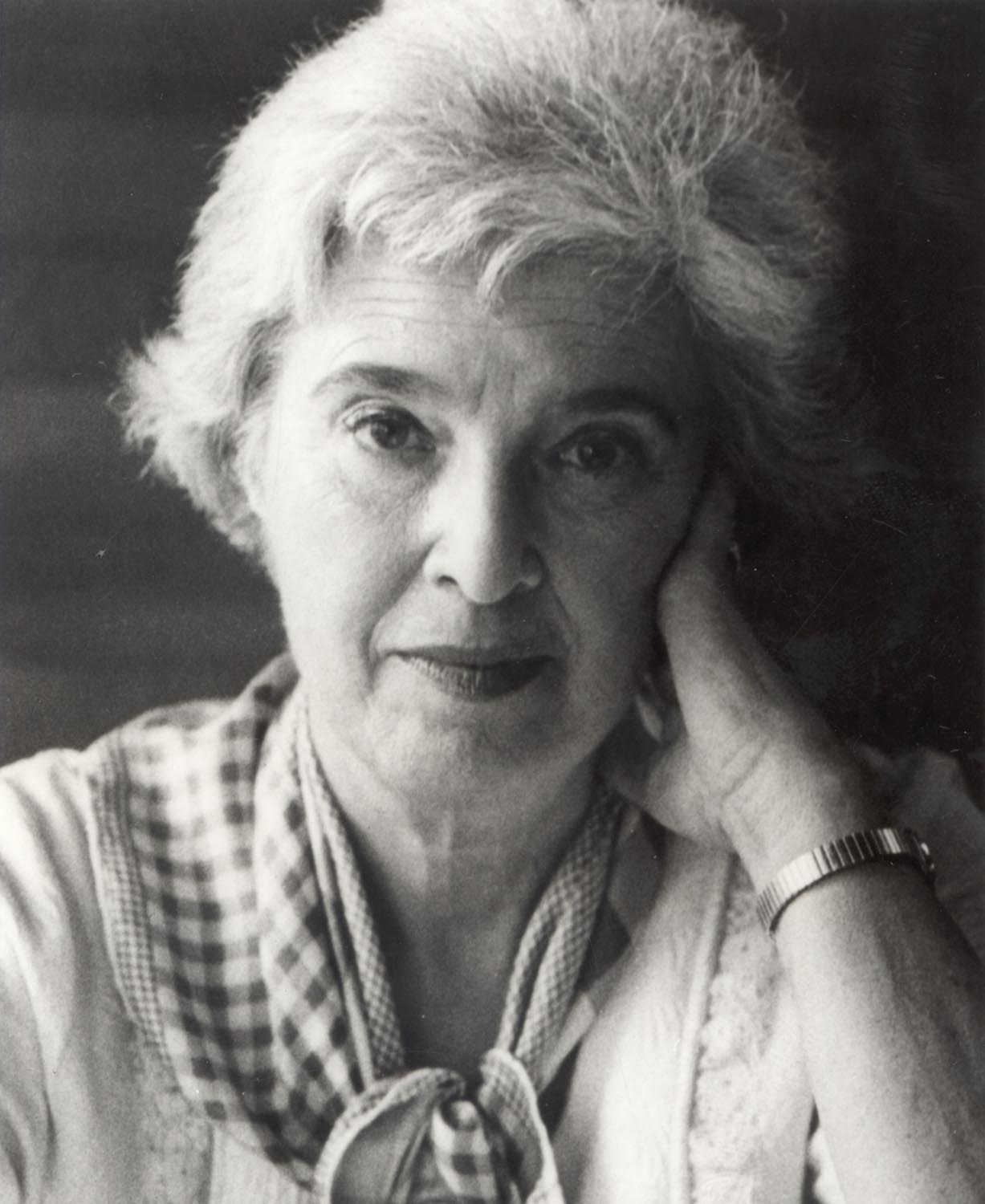 Black-and-white portrait of Gerda Lerner resting her head against her hand and looking toward the camera.