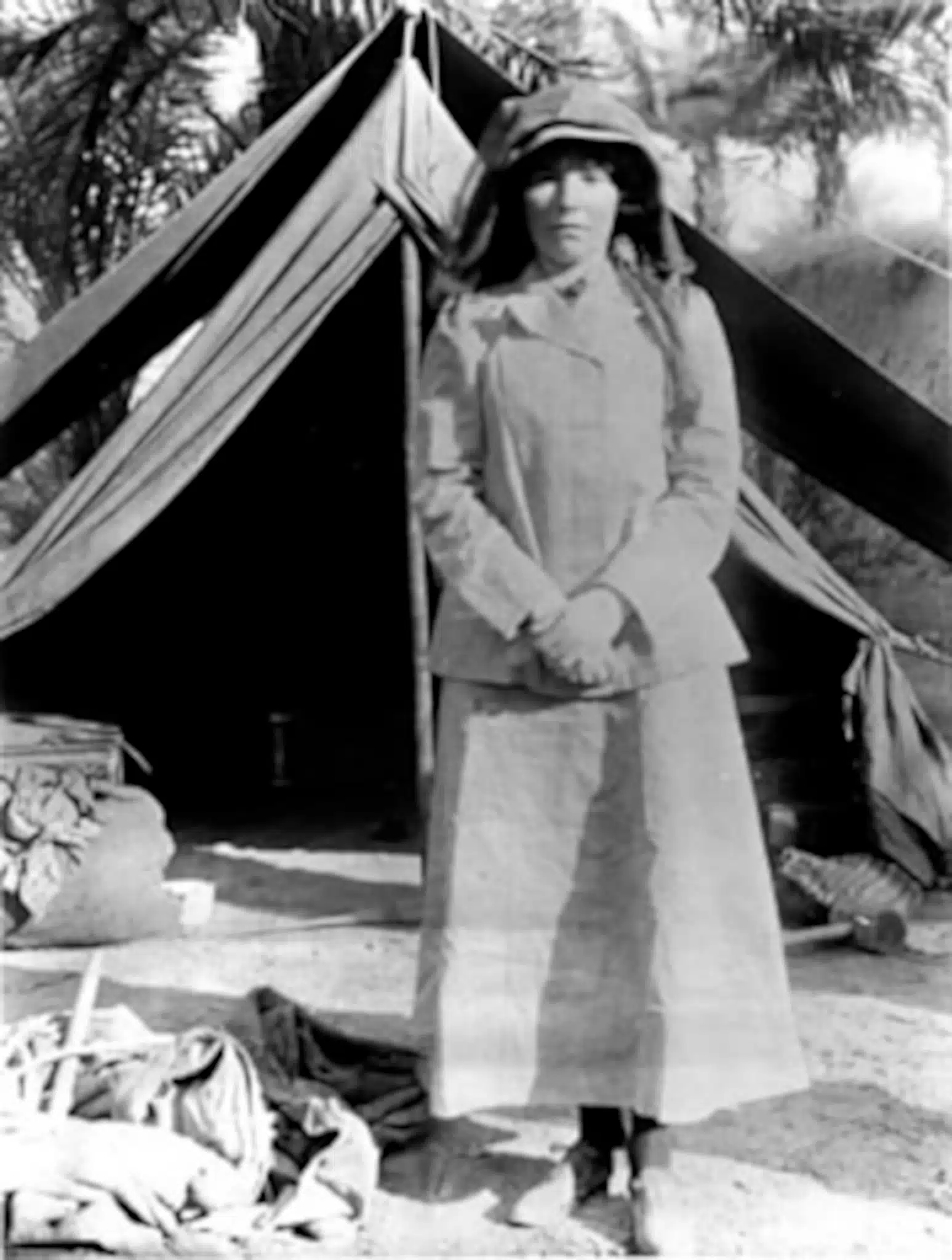 Gertrude Bell stands in front of a tent in Iraq.