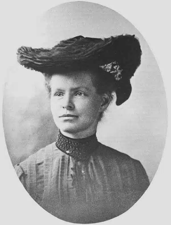 Nettie Stevens wearing a dark hat and a high-collared blouse.