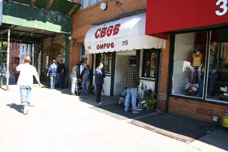 The CBGB club's storefront with its awning and people on the sidewalk.