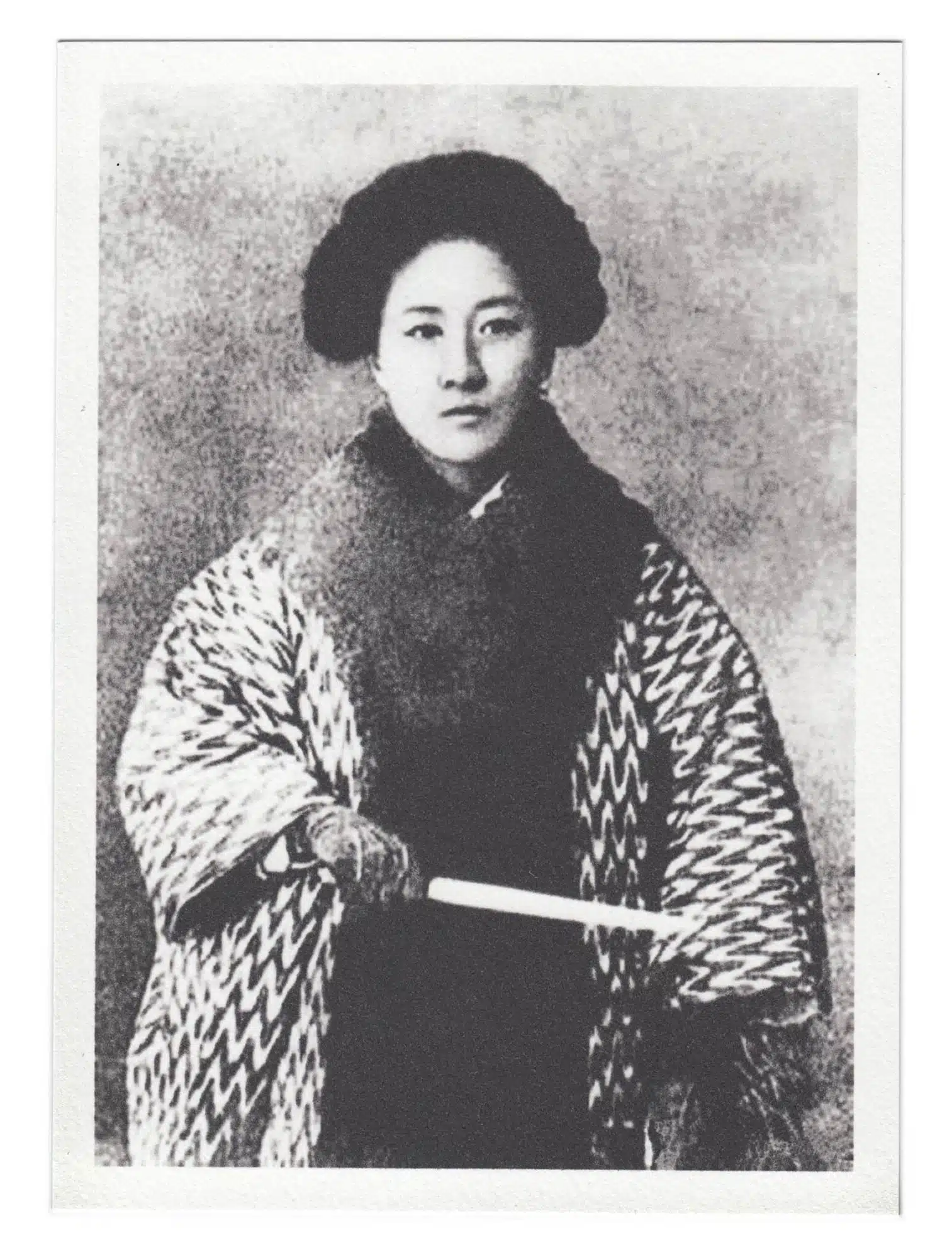 Qiu Jin faces the camera in a patterned garment, with her hands together.