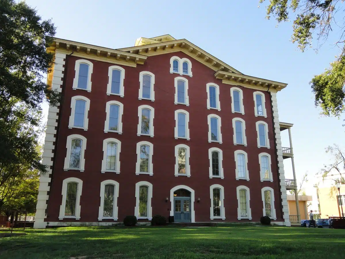 Red brick Estey Hall at Shaw University, with white-trimmed windows and a lawn in front.