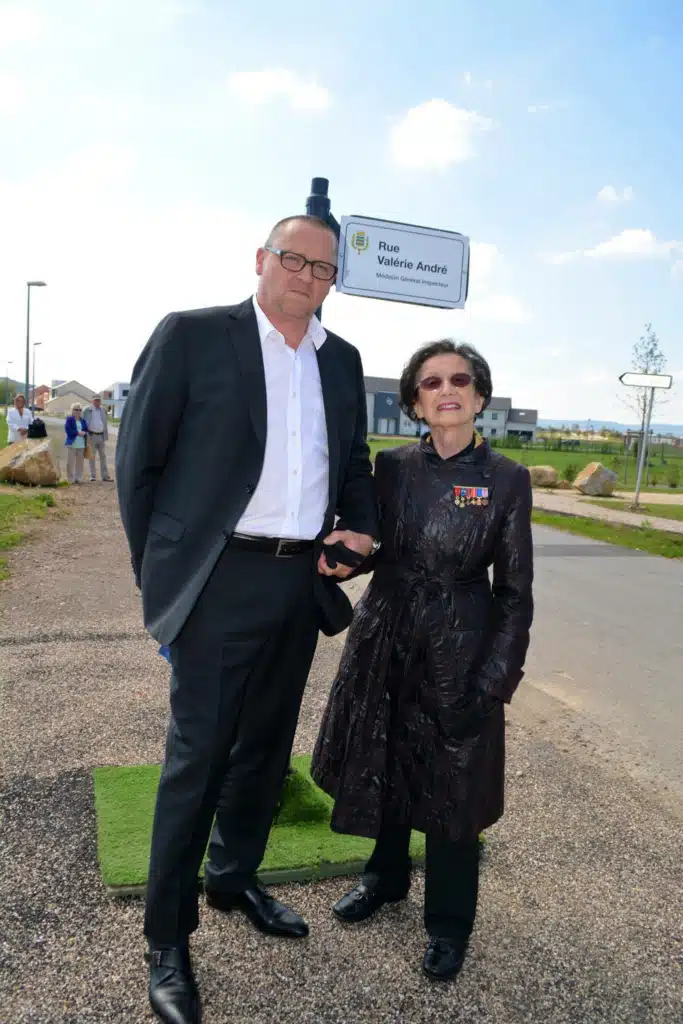 Valérie André stands beside another person at an outdoor street inauguration.